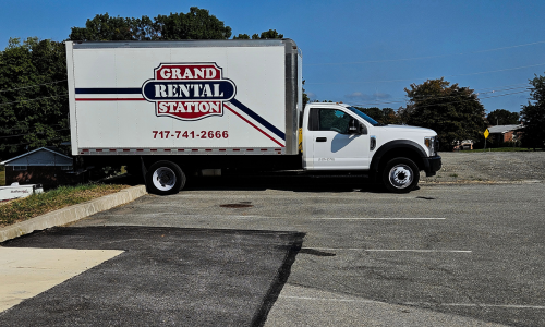 Delivery truck with Grand Rental Station logo printed on the side